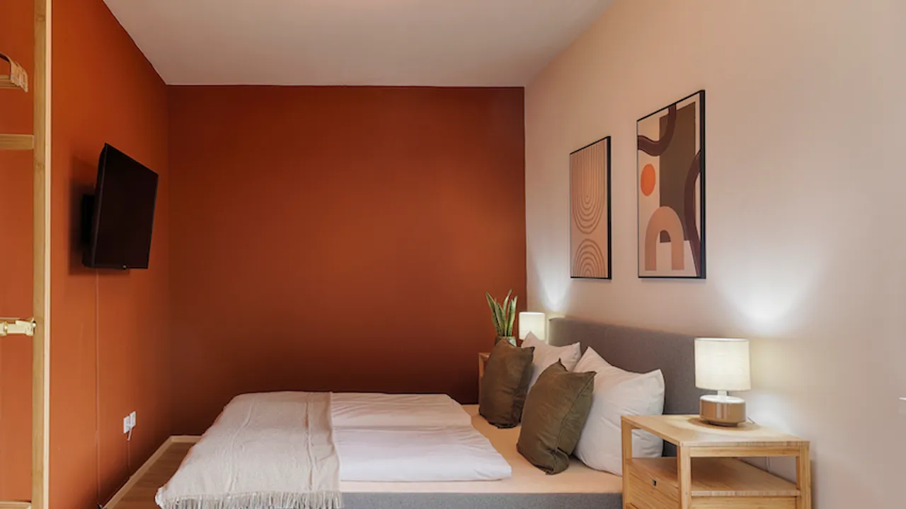 The bedroom in our red apartment offers enough space for a comfortable stay. 